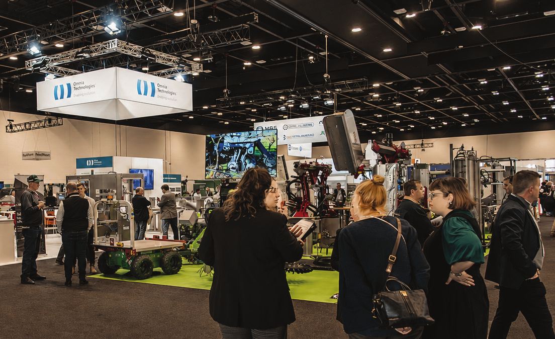 Visitors moving between exhibitor stands and machinery displays in the WineTech exhibition hall